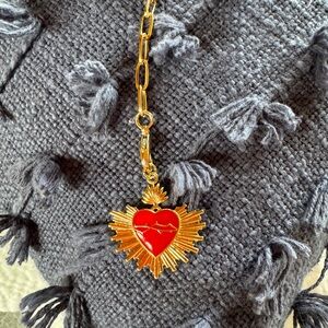 Heart charm dangling from an adjustable paperclip necklace
